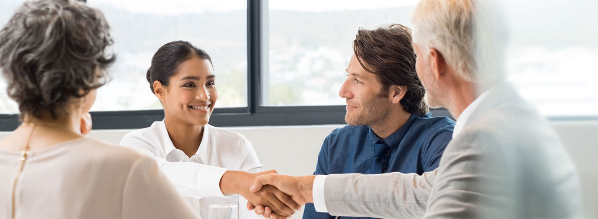 Colleagues shaking hands in an office meeting room