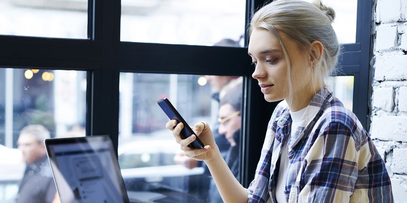 Woman at coffee shop with laptop and mobile